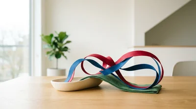 A conceptual illustration of flowing red and blue ribbons in deep green and warm cream